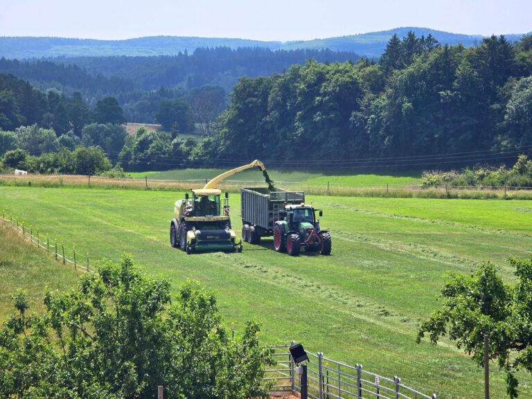 Tractor and combine harvester in a lush green landscape capturing the essence of modern farming.