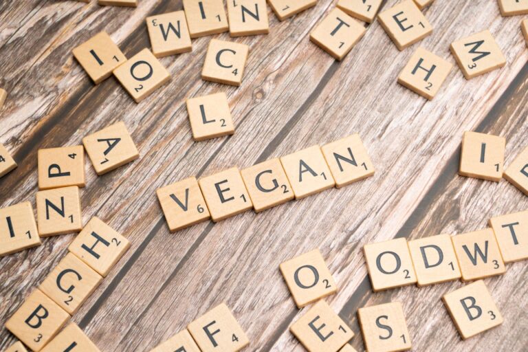 scrabble letters spelling the word vegan on a wooden table